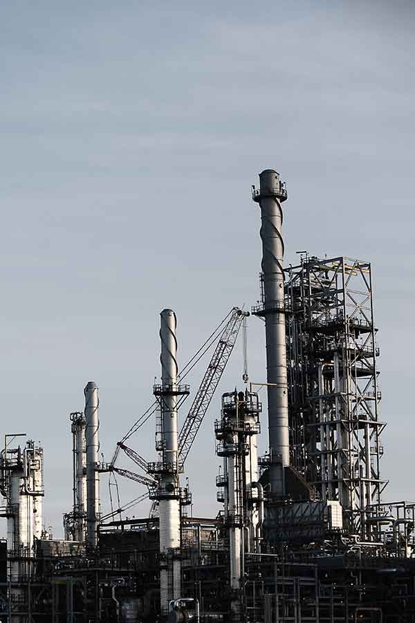 Industrial refinery complex with distillation towers and piping.